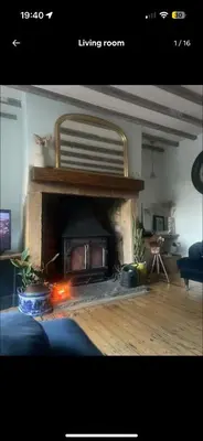 a living room with a fireplace in the middle at Squirrel Cottage in Ribchester