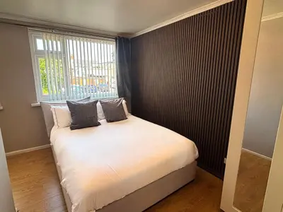 a small bedroom with a white bed with a window at SmithStayz Poulton in Poulton le Fylde