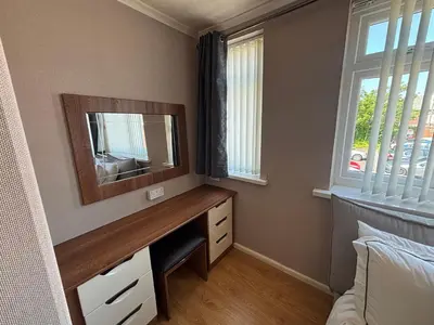 a bedroom with a desk with a television and a window at SmithStayz Poulton in Poulton le Fylde