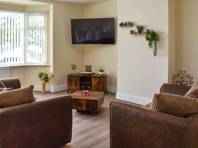 a living room with two couches and a tv at Ocean Breeze in Heysham