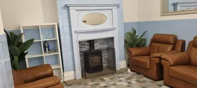 a living room with a fireplace and two chairs at 8 Guests - Free Parking - Full Equipped House in Saint Helens
