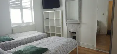 a white room with two beds and a fireplace at 8 Guests - Free Parking - Full Equipped House in Saint Helens
