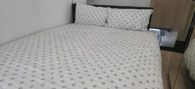 a bed with a white and gray bedspread and a pillow at 8 Guests - Free Parking - Full Equipped House in Saint Helens
