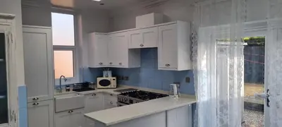 a kitchen with white cabinets and a stove top oven at 8 Guests - Free Parking - Full Equipped House in Saint Helens