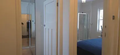 a white room with a bed and a glass door at 8 Guests - Free Parking - Full Equipped House in Saint Helens