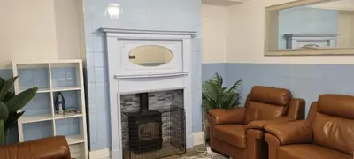 a living room with a fireplace and a mirror at 8 Guests - Free Parking - Full Equipped House in Saint Helens