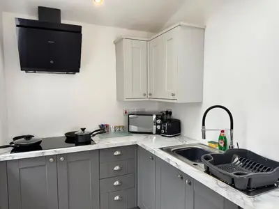 a kitchen with white cabinets and a sink and a microwave at 6B 3Bath - Free Parking - TVs In EVERY Room in Liverpool