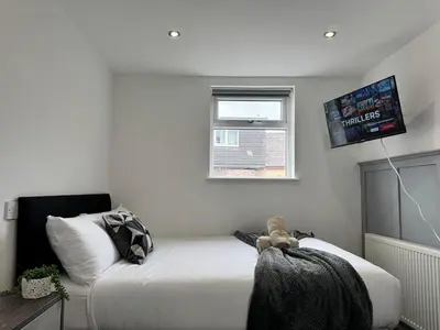 a bedroom with a bed and a flat screen tv at 6B 3Bath - Free Parking - TVs In EVERY Room in Liverpool