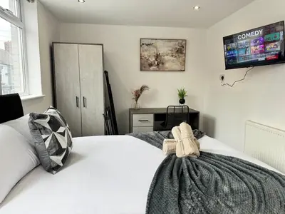 a bedroom with a white bed and a tv on the wall at 6B 3Bath - Free Parking - TVs In EVERY Room in Liverpool