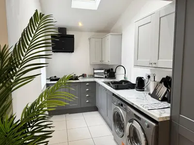 a kitchen with a washer and dryer in it at 6B 3Bath - Free Parking - TVs In EVERY Room in Liverpool