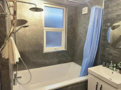 a bathroom with a shower and a tub and a sink at 5 Mins to Anfield, 2 Bed, Mosaic Art House in Liverpool