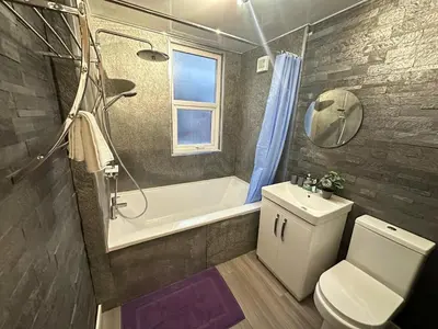a bathroom with a toilet and a tub and a sink at 5 Mins to Anfield, 2 Bed, Mosaic Art House in Liverpool