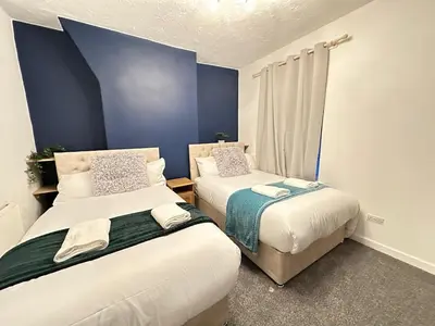 two beds in a room with blue walls at 5 Mins to Anfield, 2 Bed, Mosaic Art House in Liverpool