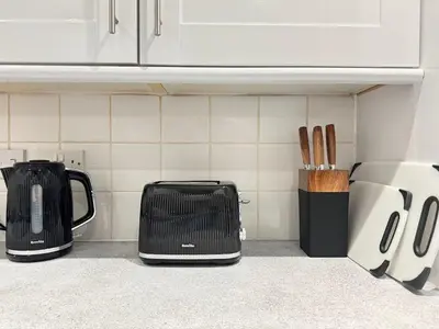 a kitchen counter with two toasters and a toaster and knives at Coastal 2 Bathroom Apartment, Free Parking in Moreton