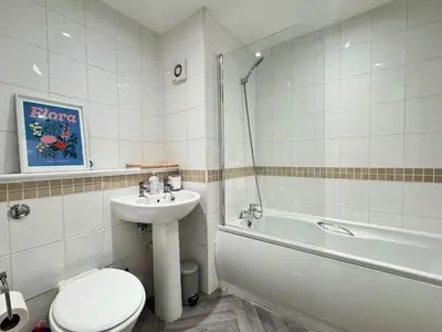 a bathroom with a toilet and a sink and a tub at Coastal 2 Bathroom Apartment, Free Parking in Moreton