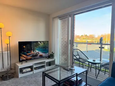 a living room with a tv and a large window at Coastal 2 Bathroom Apartment, Free Parking in Moreton