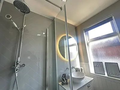 a bathroom with a shower with a sink and a mirror at Stylish Highland-Theme 2BR Sefton Park in Liverpool