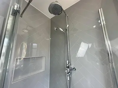 a shower stall with a glass door with a shower head at Stylish Highland-Theme 2BR Sefton Park in Liverpool