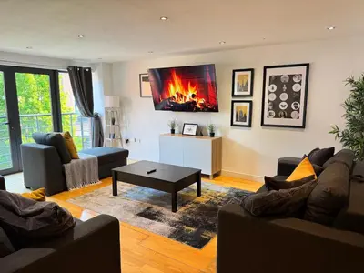 a living room with two couches and a fireplace at Balcony Free Parking Huge TV City Centre Apt in Liverpool