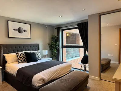 a bedroom with a bed and a large window at Balcony Free Parking Huge TV City Centre Apt in Liverpool