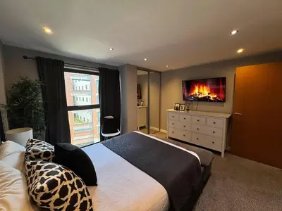 a bedroom with a bed and a tv on the wall at Balcony Free Parking Huge TV City Centre Apt in Liverpool