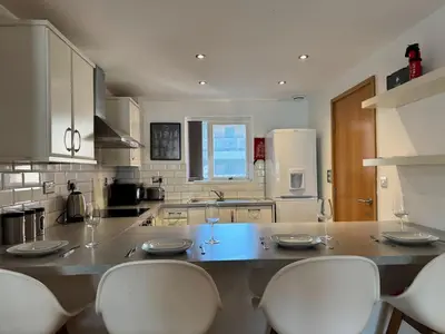 a kitchen with a counter with three wine glasses on it at Balcony Free Parking Huge TV City Centre Apt in Liverpool