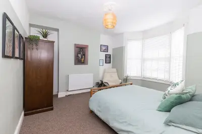a bedroom with a bed and a chair in it at Very Spacious 2 Bath Free Parking in Liverpool