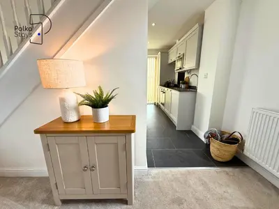 a living room with a staircase and a table with a lamp at No 1 PolkaStays Ivy Farm Willow Cottage in Plumpton