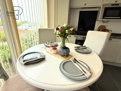a white table with a vase of flowers on it at No 1 PolkaStays Ivy Farm Willow Cottage in Plumpton