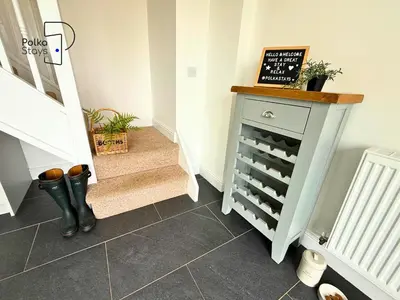 a staircase with a dresser with a wine rack at No 1 PolkaStays Ivy Farm Willow Cottage in Plumpton