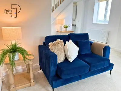 a blue couch with white pillows in a living room at No 1 PolkaStays Ivy Farm Willow Cottage in Plumpton