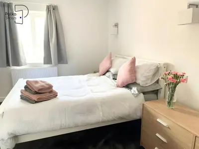 a bedroom with a white bed with pink pillows at No 5 PolkaStays Ivy Farm Paddock Lodge in Brown Moss Side