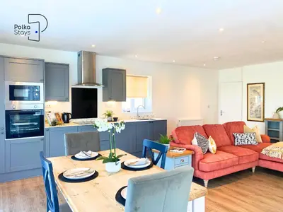 a living room with a red couch and a table at No 5 PolkaStays Ivy Farm Paddock Lodge in Brown Moss Side