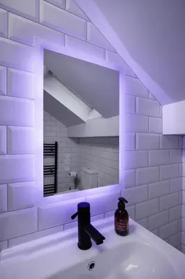 a white bathroom with a mirror and a sink at The Coaster Loft Apartments by STAMP SA in Blackpool