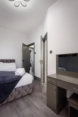 a bedroom with a bed and a desk with a television at The Coaster Loft Apartments by STAMP SA in Blackpool