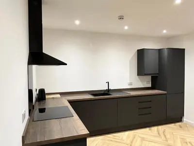 a kitchen with a black refrigerator and a sink at Oceans 45 in Blackpool