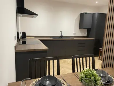 a kitchen with a table and chairs and a kitchen with a counter at Oceans 45 in Blackpool