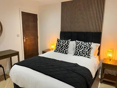 a bedroom with a large bed with black and white pillows at Oceans 45 in Blackpool