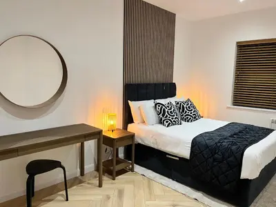 a bedroom with a bed with a mirror and a desk at Oceans 45 in Blackpool