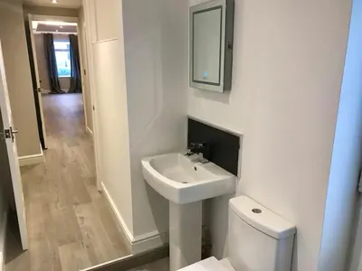a white bathroom with a sink and a toilet at Barrow Centre Stylish 1 Bed flat in Barrow in Furness