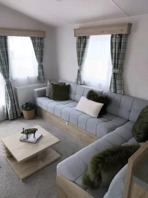 a living room with a gray couch and a table at Luxury 6 berth Caravan Lytham in Preston