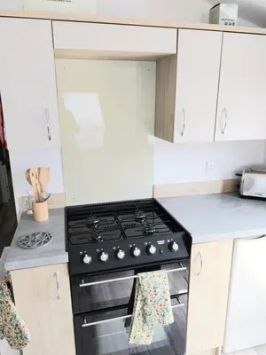 a kitchen with a stove and white cabinets at Luxury 6 berth Caravan Lytham in Preston