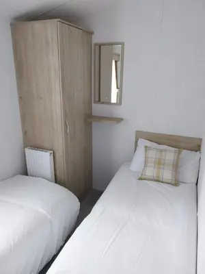 two beds in a small room with a mirror at Luxury 6 berth Caravan Lytham in Preston