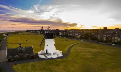 a light house with a windmill on a field at Luxury 6 berth Caravan Lytham in Preston