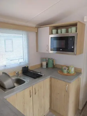 a small kitchen with a sink and a microwave at Luxury 6 berth Caravan Lytham in Preston
