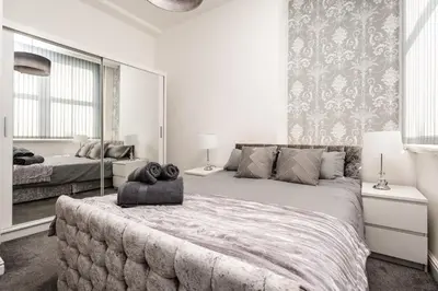a bedroom with a large bed with a large mirror at Castle St Steps to Ivy Washer Pet-Friendly in Liverpool