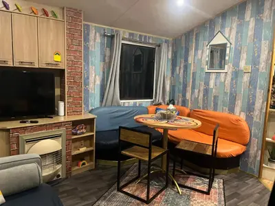 a small room with a bed and a table with chairs at The Rainbow's nest in Morecambe
