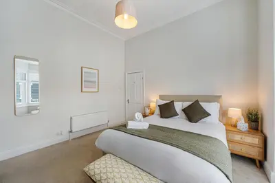 a white bedroom with a large bed and two lamps at Watford Lodge - Air Host & Stay - A Home in the Heart of Anfield in Liverpool