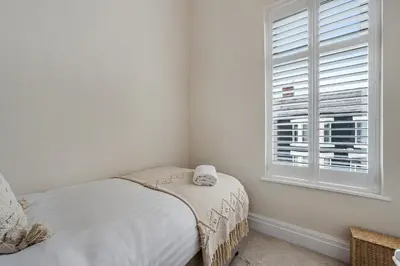a white bedroom with a bed and a window at Watford Lodge - Air Host & Stay - A Home in the Heart of Anfield in Liverpool