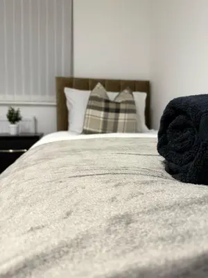 a bed with a blanket and a pillow on it at Spacious & Modern house in St Helens in Saint Helens